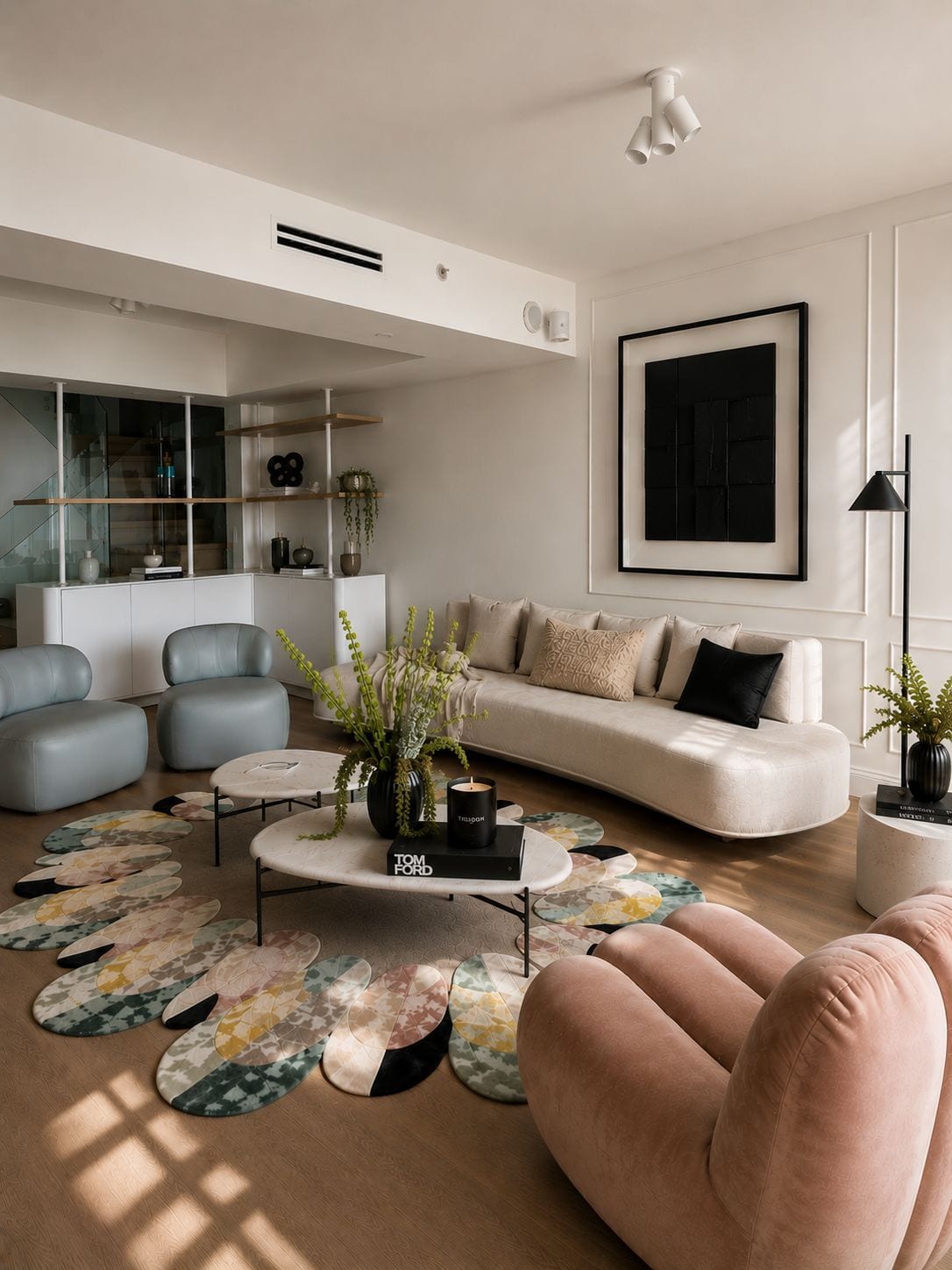 The living room in afternoon light — a curved bouclé sofa, dusty blue chairs, and a floor of layered pattern