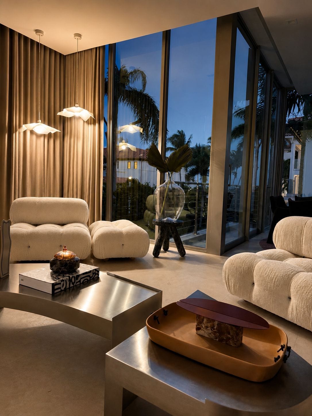 A Glumm & Co interior at dusk, glass open to the palms and the blue hour