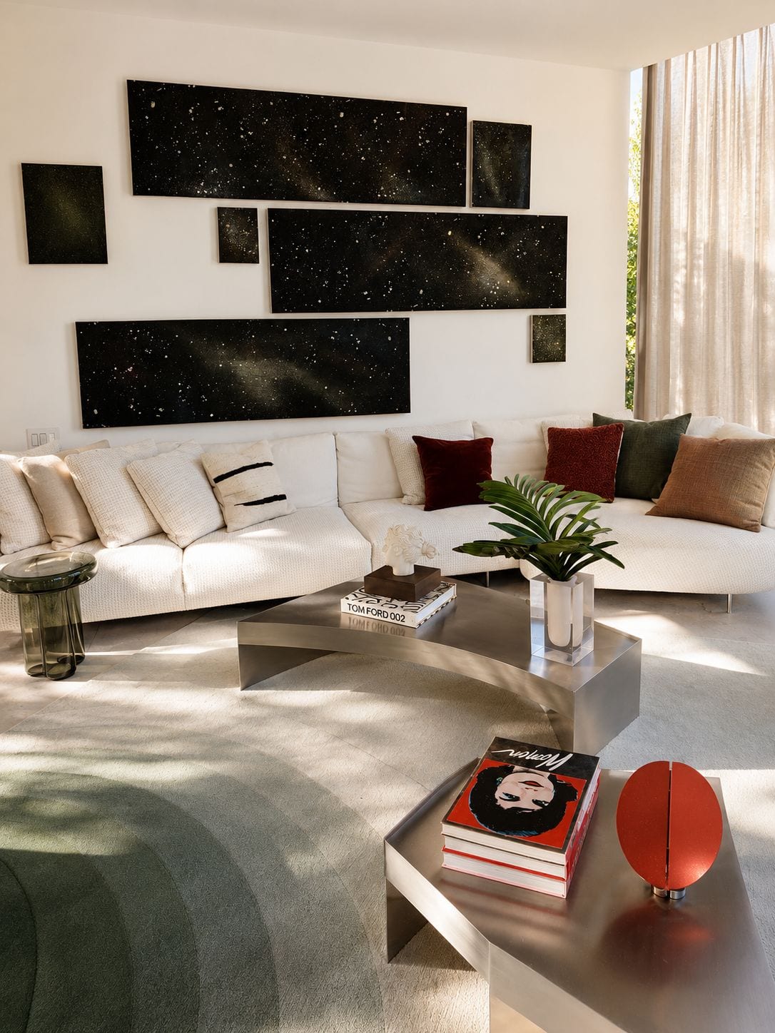 The daytime living room — white sectional beneath a wall of star-field paintings