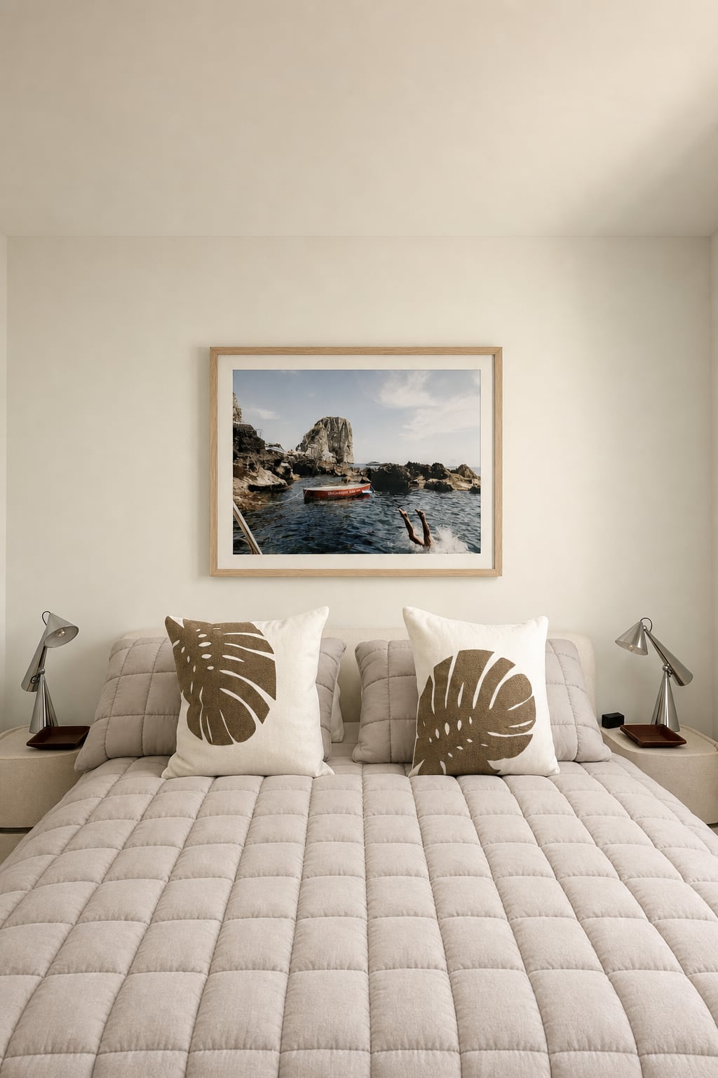 The primary bedroom — a coastal diving photograph above the bed, palm-leaf pillows